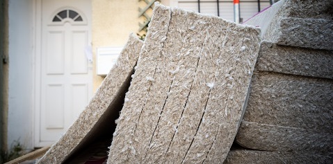 vue de rouleaux de laine de chanvre devant une maison en construction