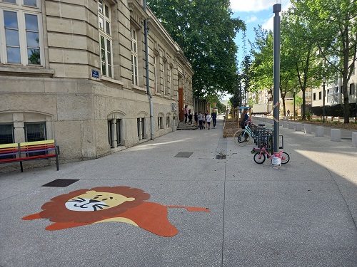 Lion dessiné au sol devant une école