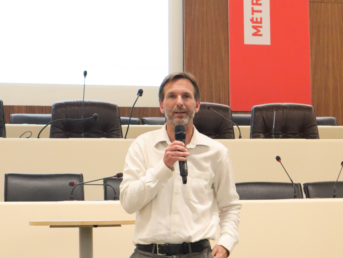 Homme blanc en chemise blanche dans une salle de conférence