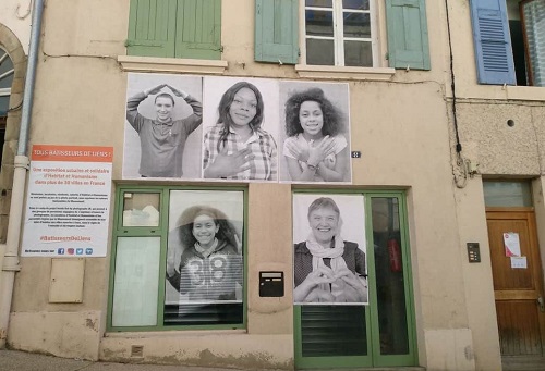 Affiches avec des habitants sur le facade d'une maison rénovée par Habitat et humanisme (projet de Langres)
