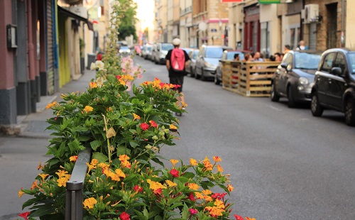 photo d'une rue avec terrasse aménagée sur une place de parking