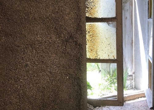 intérieur d'une maison avec un isolant terre paille, et une fenêtre ouverte