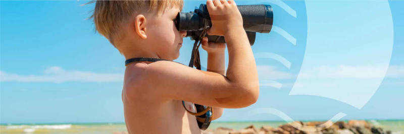 enfant regardant la mer aux jumelles