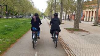 2 personnes roulent à vélo sur piste cyclable en ville