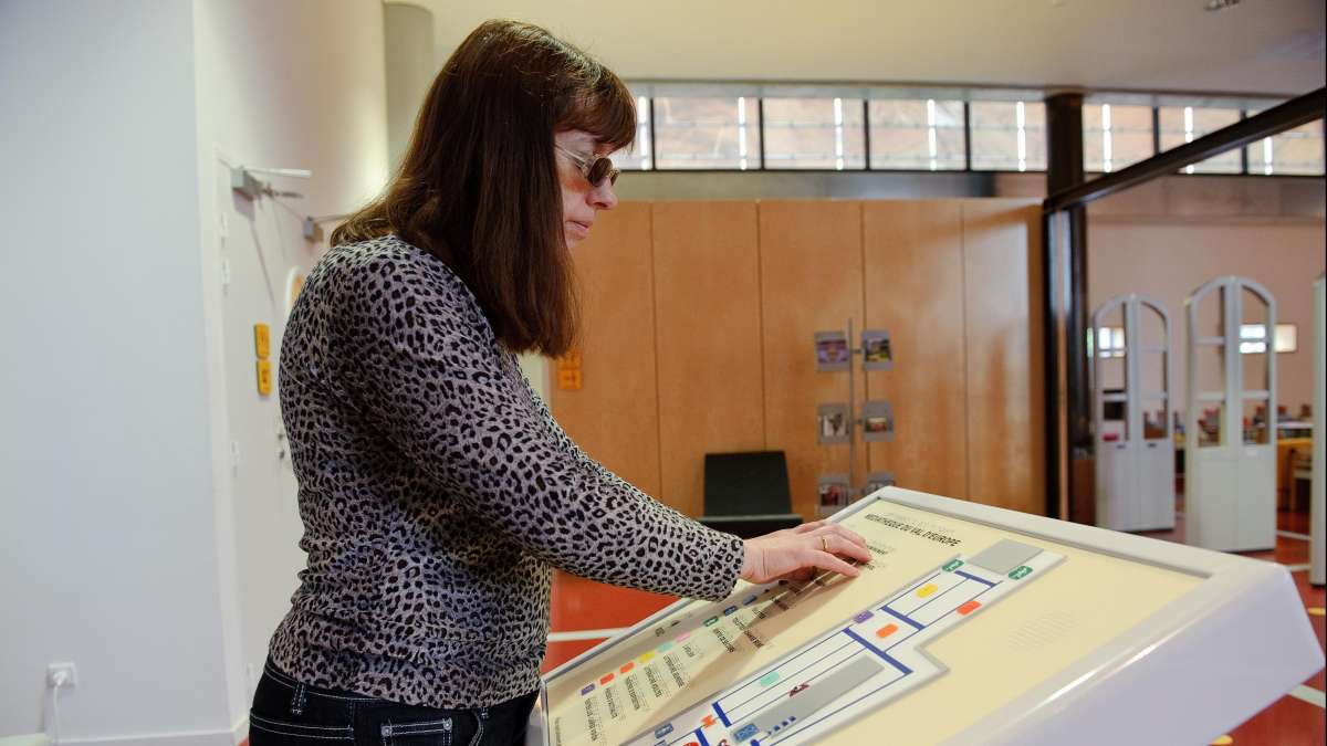 Personne consultant un plan en relief et en braille