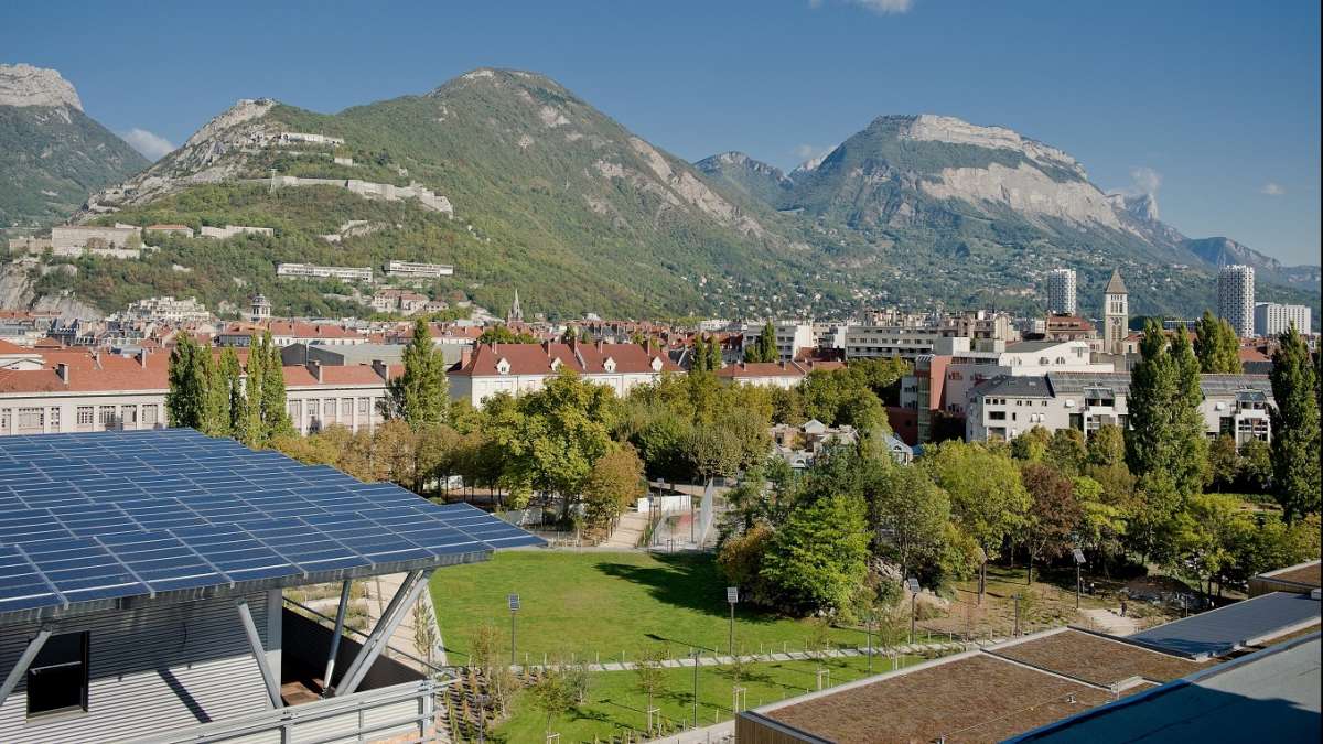 Paysage urbain en montagne avec un toit de panneaux solaires au 1er plan