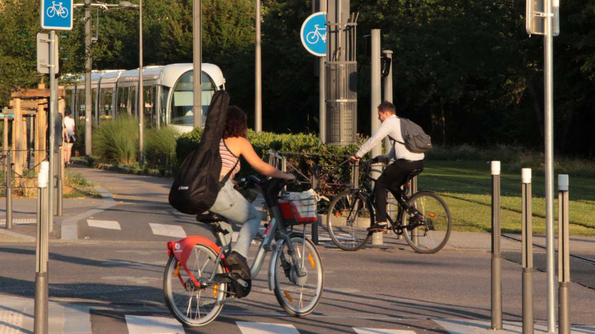 Vélos sur une piste cyclable et tramway à Lyon