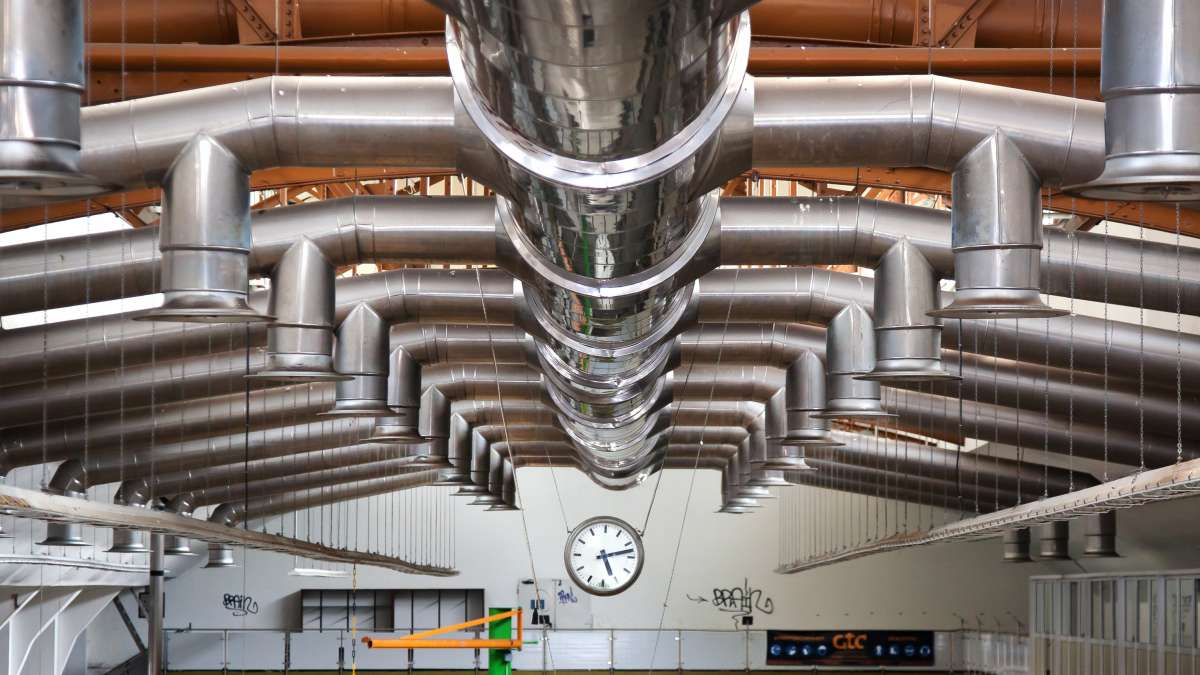 Systèmes d'aération dans une usine, vue des tuyaux au plafond