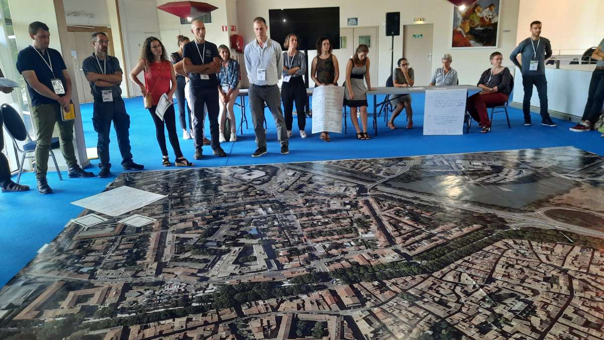 Groupe de participants devant une très grande carte d'une ville en vue satellite (5 m environ)