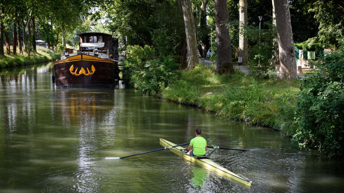 kayakiste et péniche sur le canal du Midi